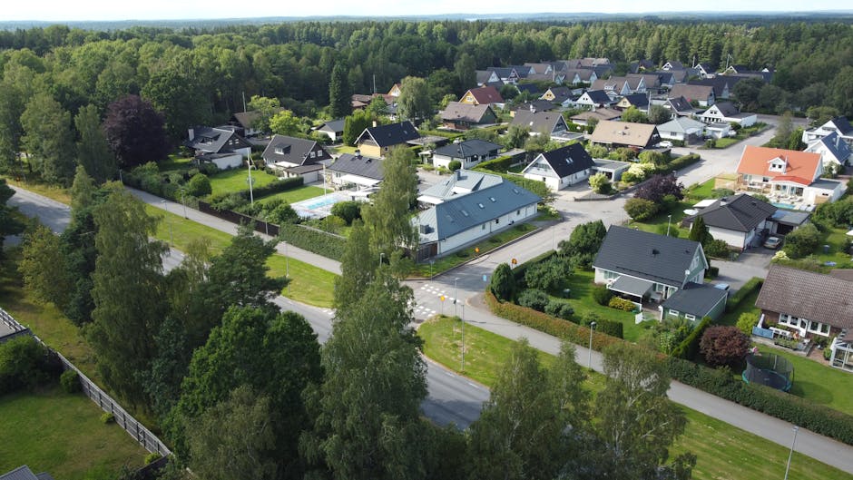 Aerial view of suburban houses surrounded by lush greenery in a Swedish neighborhood.
